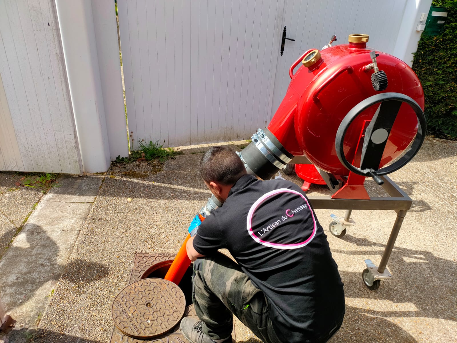 Artisan spécialisé effectuant une intervention de chemisage sur site avec équipement professionnel rouge