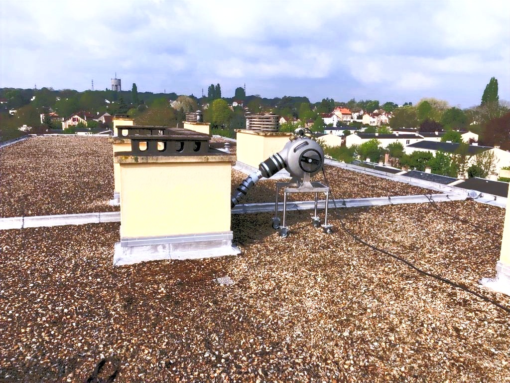 Expert du chemisage intervenant sur une toiture avec équipements spécialisés pour chemisage d'évacuations